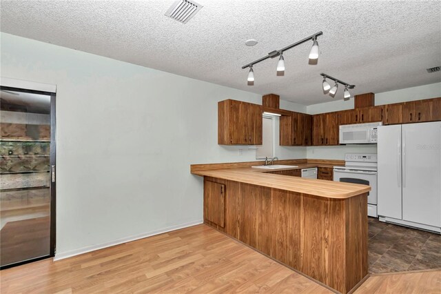 6421 NW 61st St, Ocala, FL 34482 - kitchen with white appliances, a peninsula, butcher block counters, a textured ceiling, and a sink