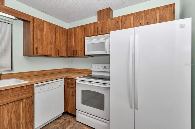 6421 NW 61st St, Ocala, FL 34482 - kitchen featuring white appliances, a sink, light countertops, brown cabinetry, and a textured ceiling