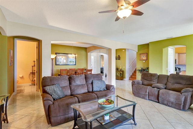 2631 Captains Ct, Kissimmee, FL 34746 - living room with arched walkways, light tile patterned flooring, stairway, and a ceiling fan