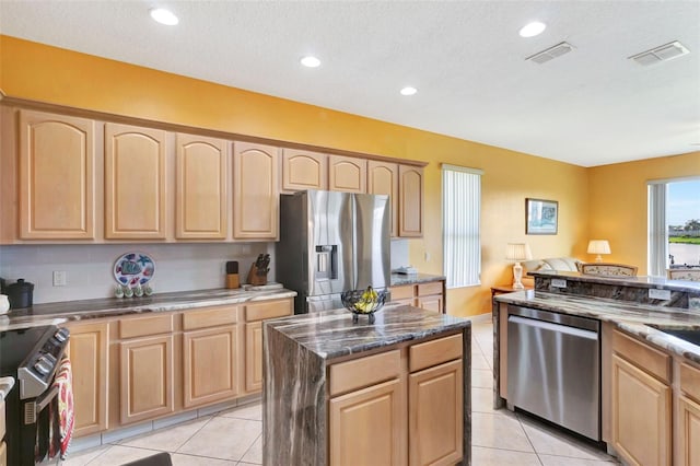 2631 Captains Ct, Kissimmee, FL 34746 - kitchen with stainless steel appliances, light brown cabinetry, dark stone countertops, light tile patterned flooring, and recessed lighting