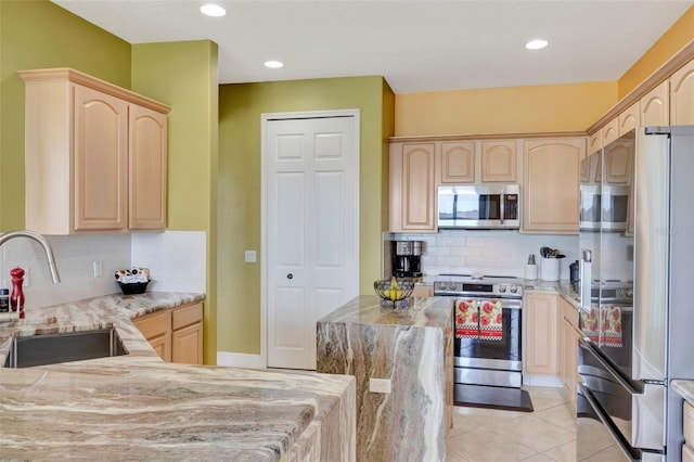2631 Captains Ct, Kissimmee, FL 34746 - kitchen with stainless steel appliances, light brown cabinets, backsplash, light stone countertops, and recessed lighting