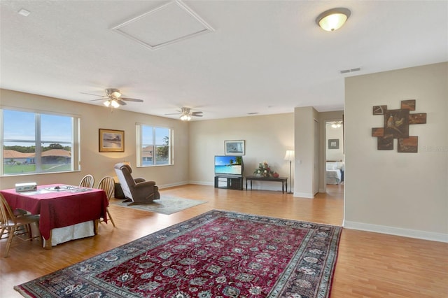 2631 Captains Ct, Kissimmee, FL 34746 - living area with healthy amount of natural light, light wood-type flooring, a ceiling fan, and attic access