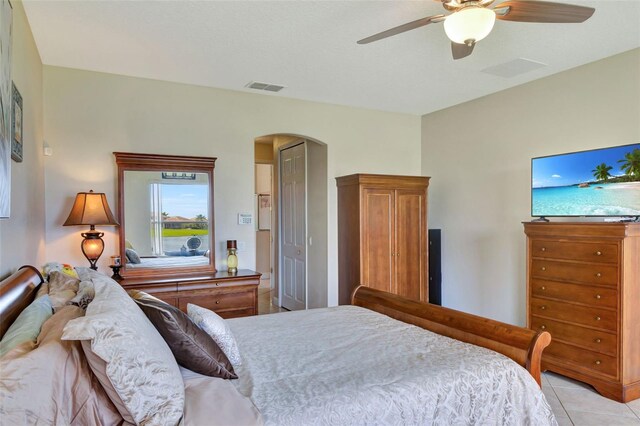 2631 Captains Ct, Kissimmee, FL 34746 - bedroom featuring arched walkways, ceiling fan, and light tile patterned floors