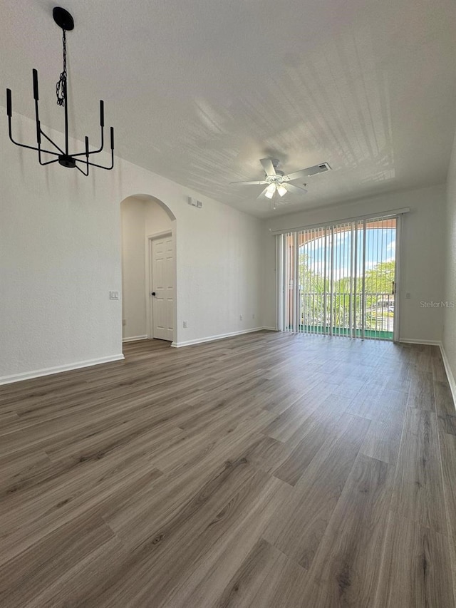 13512 Turtle Marsh Loop Unit 729, Orlando, FL 32837 - unfurnished living room with ceiling fan, arched walkways, wood finished floors, a chandelier, and baseboards
