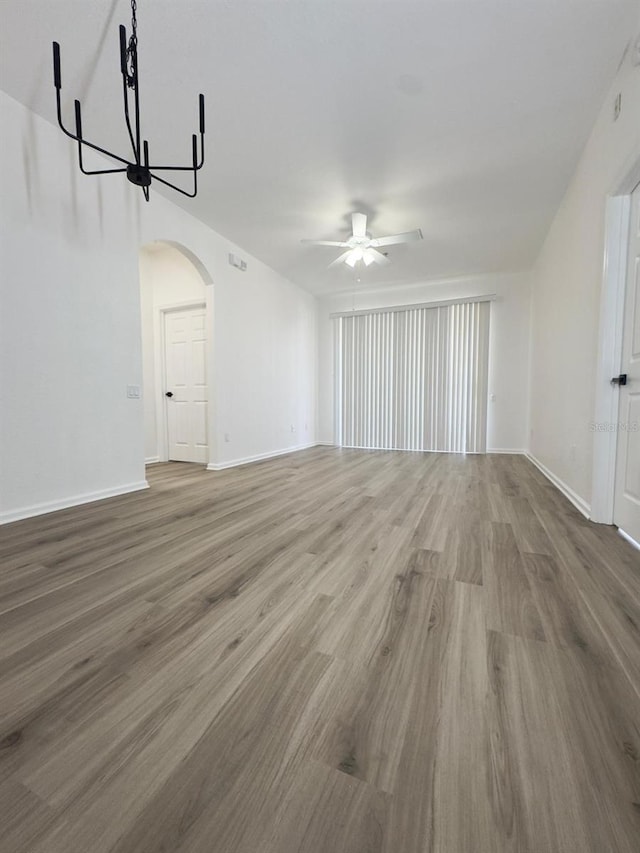 13512 Turtle Marsh Loop Unit 729, Orlando, FL 32837 - unfurnished living room with a ceiling fan, arched walkways, wood finished floors, and baseboards