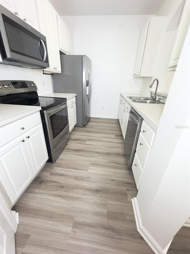 13512 Turtle Marsh Loop Unit 729, Orlando, FL 32837 - kitchen with stainless steel appliances, a sink, white cabinetry, light countertops, and baseboards