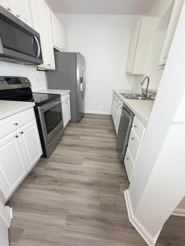 13512 Turtle Marsh Loop Unit 729, Orlando, FL 32837 - kitchen featuring stainless steel appliances, a sink, white cabinets, baseboards, and light countertops