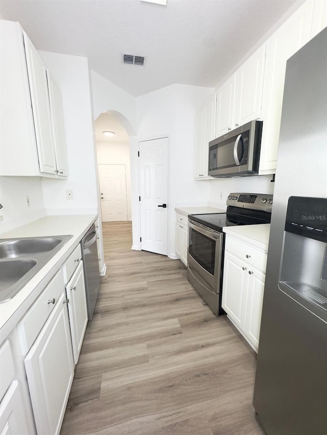 13512 Turtle Marsh Loop Unit 729, Orlando, FL 32837 - kitchen with stainless steel appliances, white cabinets, light countertops, and light wood-style flooring