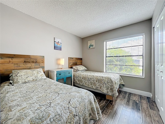3944 Atrium Dr Unit 4, Orlando, FL 32822 - bedroom featuring dark wood-style floors, multiple windows, baseboards, and a textured ceiling