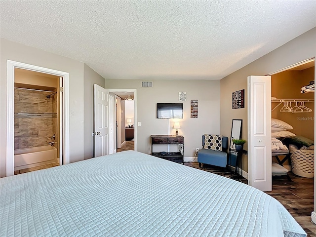 3944 Atrium Dr Unit 4, Orlando, FL 32822 - bedroom with wood finished floors, a textured ceiling, a spacious closet, baseboards, and ensuite bathroom