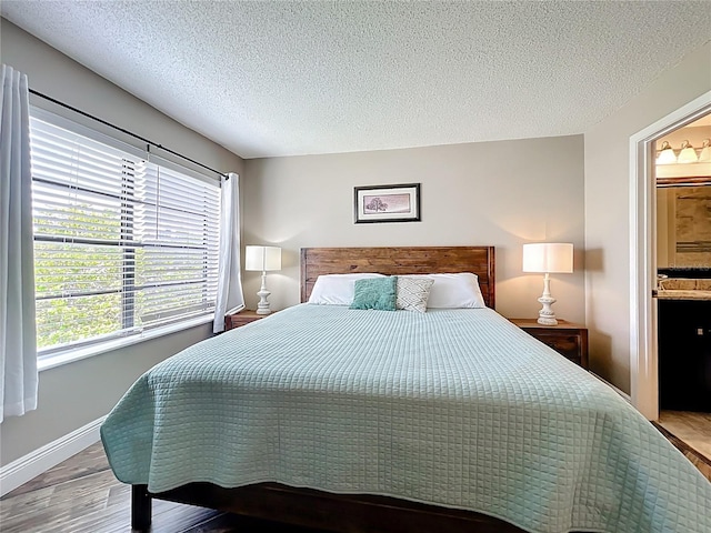 3944 Atrium Dr Unit 4, Orlando, FL 32822 - bedroom with wood finished floors, a textured ceiling, baseboards, and connected bathroom