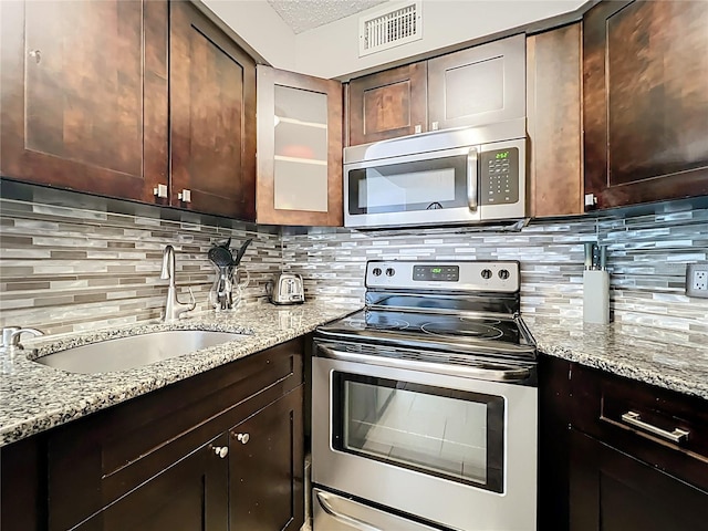 3944 Atrium Dr Unit 4, Orlando, FL 32822 - kitchen featuring stainless steel appliances, a sink, tasteful backsplash, and light stone counters