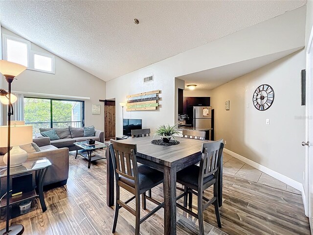 3944 Atrium Dr Unit 4, Orlando, FL 32822 - dining space featuring a textured ceiling, wood finished floors, lofted ceiling, and baseboards