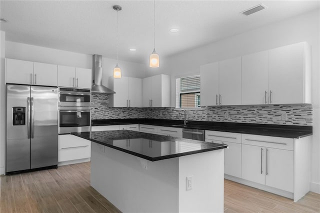 1812 Stoneywood Way, Apopka, FL 32712 - kitchen featuring appliances with stainless steel finishes, wall chimney exhaust hood, light wood finished floors, dark countertops, and recessed lighting