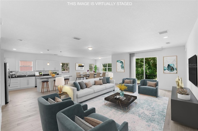 1812 Stoneywood Way, Apopka, FL 32712 - living area with light wood-style floors, recessed lighting, and a textured ceiling