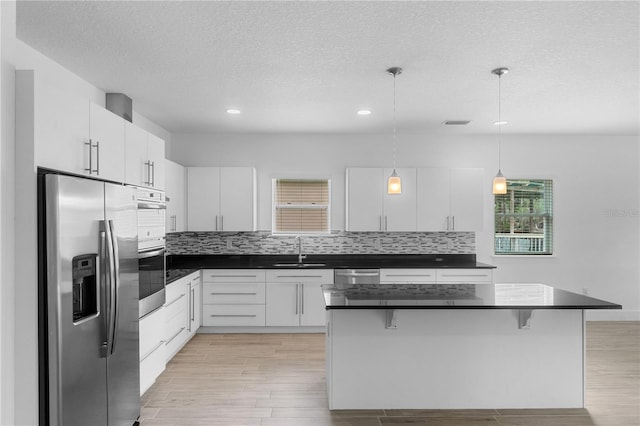 1812 Stoneywood Way, Apopka, FL 32712 - kitchen featuring stainless steel appliances, a sink, dark countertops, a kitchen bar, and recessed lighting