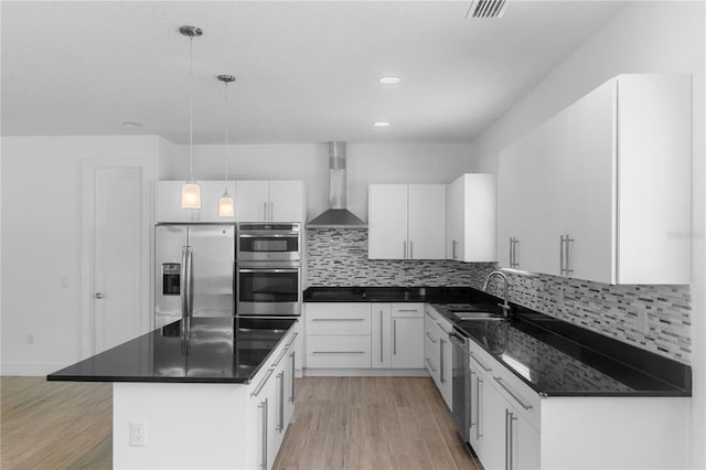 1812 Stoneywood Way, Apopka, FL 32712 - kitchen featuring wall chimney range hood, appliances with stainless steel finishes, dark countertops, light wood-style flooring, and a kitchen island