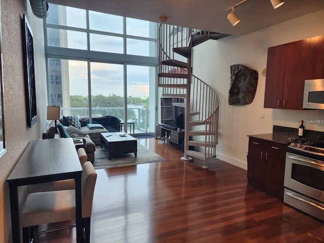 150 E Robinson St Unit 419, Orlando, FL 32801 - living area with stairs, dark wood-style flooring, baseboards, and rail lighting