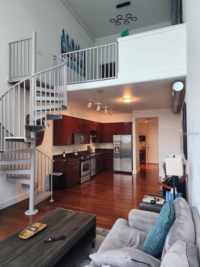 150 E Robinson St Unit 419, Orlando, FL 32801 - living room featuring stairs, dark wood-style floors, a high ceiling, and baseboards