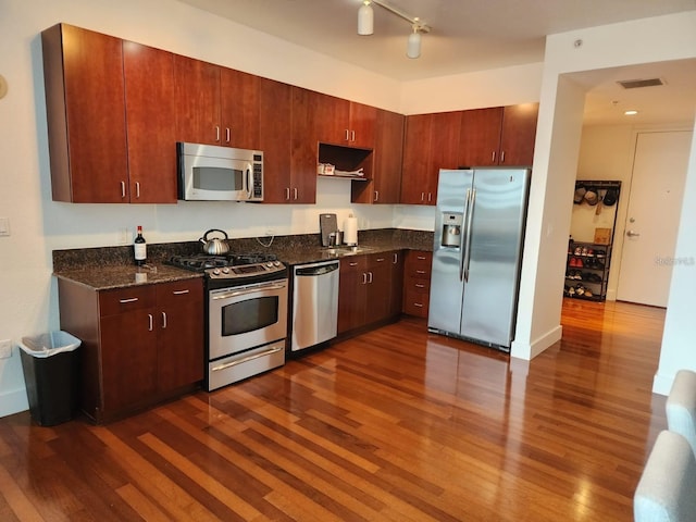 150 E Robinson St Unit 419, Orlando, FL 32801 - kitchen with stainless steel appliances, dark wood-style floors, and dark stone countertops