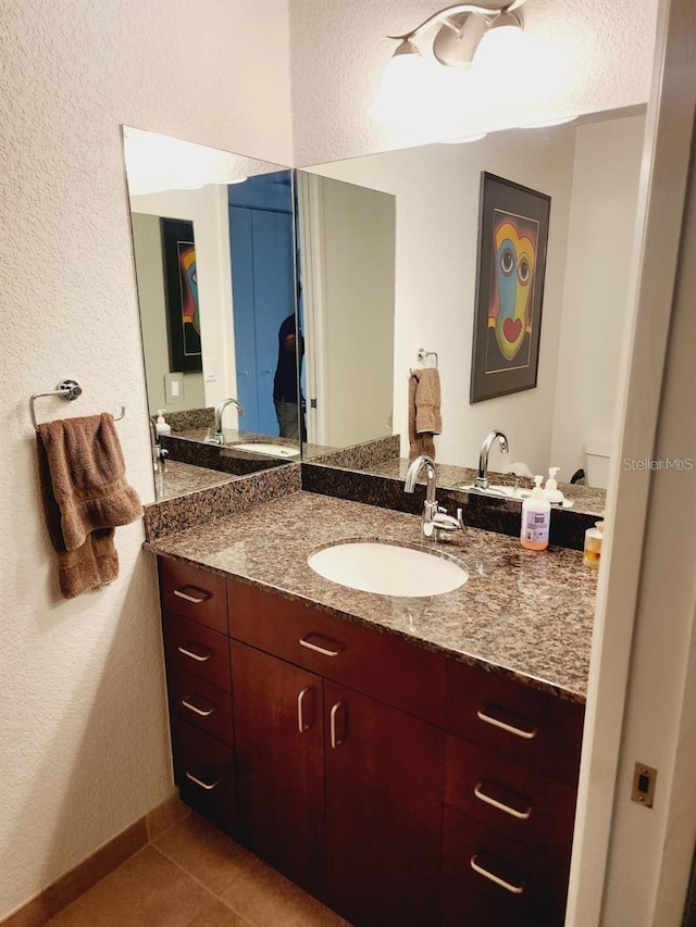150 E Robinson St Unit 419, Orlando, FL 32801 - bathroom featuring vanity, a textured wall, and tile patterned floors
