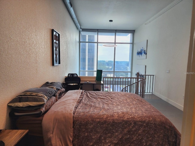 150 E Robinson St Unit 419, Orlando, FL 32801 - bedroom with a textured wall, floor to ceiling windows, and baseboards