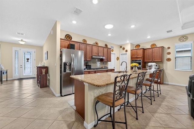 8336 SW 77th Ct, Ocala, FL 34476 - kitchen with stainless steel refrigerator with ice dispenser, a sink, under cabinet range hood, light tile patterned flooring, and a breakfast bar