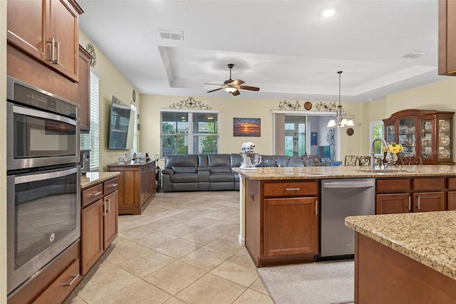 8336 SW 77th Ct, Ocala, FL 34476 - kitchen with stainless steel appliances, a raised ceiling, a sink, light tile patterned floors, and light stone counters