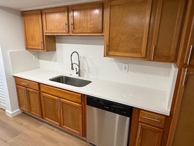 118 S Halifax Ave Unit 409, Daytona Beach, FL 32118 - kitchen featuring dishwasher, light wood-style floors, brown cabinetry, a sink, and light countertops