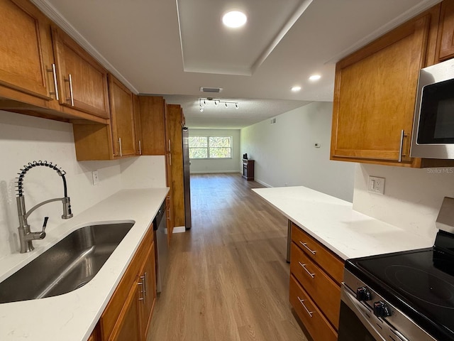 118 S Halifax Ave Unit 409, Daytona Beach, FL 32118 - kitchen featuring appliances with stainless steel finishes, a sink, brown cabinetry, and recessed lighting