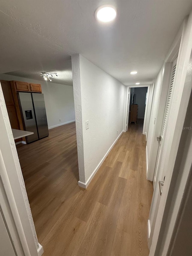 118 S Halifax Ave Unit 409, Daytona Beach, FL 32118 - corridor with light wood-style flooring, baseboards, and a textured ceiling