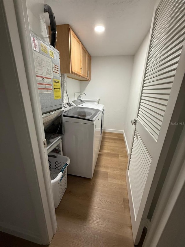 118 S Halifax Ave Unit 409, Daytona Beach, FL 32118 - washroom with independent washer and dryer, cabinet space, light wood-style flooring, baseboards, and recessed lighting