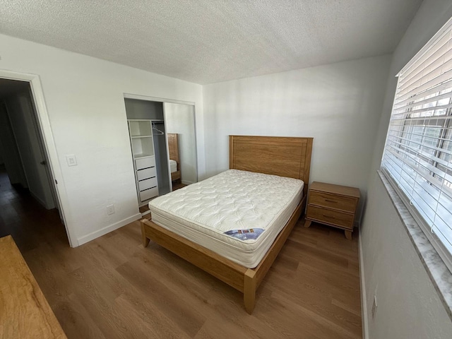 118 S Halifax Ave Unit 409, Daytona Beach, FL 32118 - bedroom with wood finished floors, a textured ceiling, a closet, and baseboards