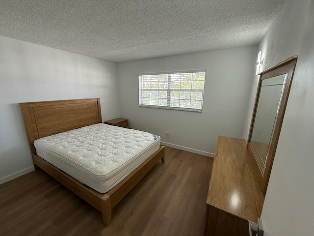 118 S Halifax Ave Unit 409, Daytona Beach, FL 32118 - bedroom featuring wood finished floors, a textured ceiling, and baseboards