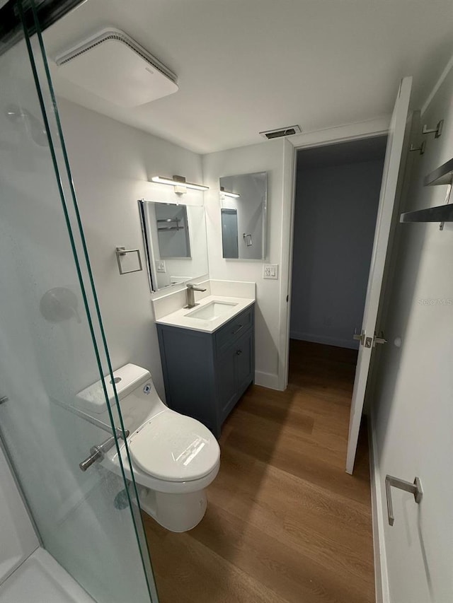 118 S Halifax Ave Unit 409, Daytona Beach, FL 32118 - full bathroom featuring vanity, a shower stall, wood finished floors, and toilet