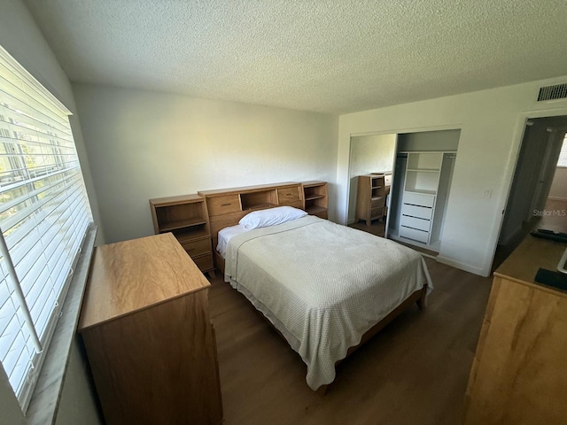 118 S Halifax Ave Unit 409, Daytona Beach, FL 32118 - bedroom featuring dark wood finished floors, a textured ceiling, and a closet