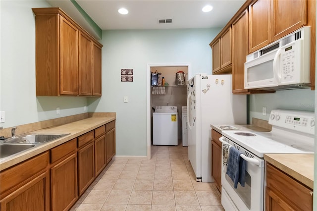 3000 Laurel Park Ln Unit 308, Kissimmee, FL 34741 - kitchen featuring white appliances, brown cabinets, washer and dryer, light countertops, and recessed lighting