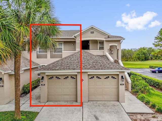 9435 Myrtle Creek Ln Unit 308, Orlando, FL 32832 - view of front of property with stucco siding, driveway, a garage, and a shingled roof