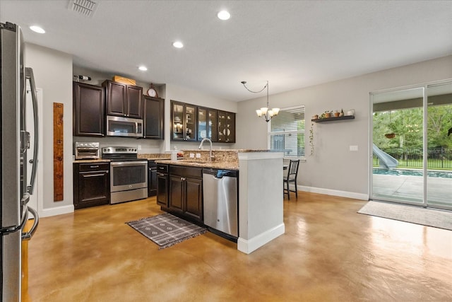 10996 Inside Loop, Orlando, FL 32825 - kitchen with appliances with stainless steel finishes, concrete floors, a chandelier, healthy amount of natural light, and recessed lighting