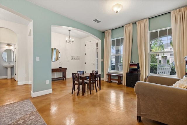 10996 Inside Loop, Orlando, FL 32825 - dining space with arched walkways, concrete flooring, and a chandelier