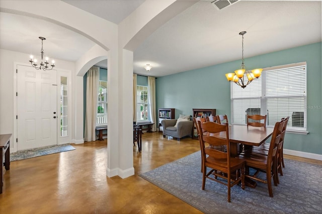 10996 Inside Loop, Orlando, FL 32825 - dining room with a chandelier, arched walkways, and concrete flooring