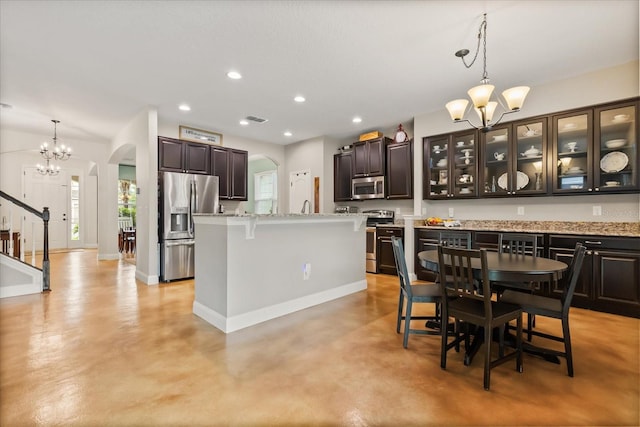 10996 Inside Loop, Orlando, FL 32825 - kitchen featuring appliances with stainless steel finishes, arched walkways, a chandelier, finished concrete flooring, and plenty of natural light