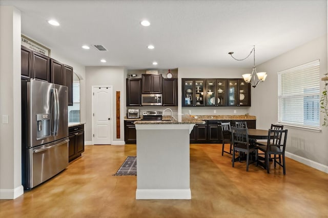 10996 Inside Loop, Orlando, FL 32825 - kitchen with appliances with stainless steel finishes, concrete flooring, glass insert cabinets, dark brown cabinetry, and recessed lighting
