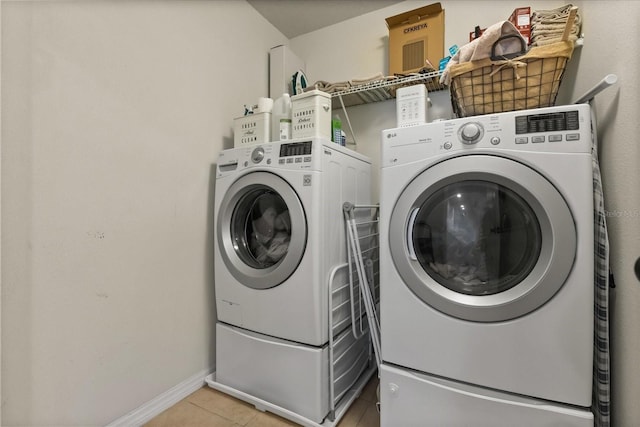 10996 Inside Loop, Orlando, FL 32825 - laundry room featuring light tile patterned floors and washing machine and clothes dryer
