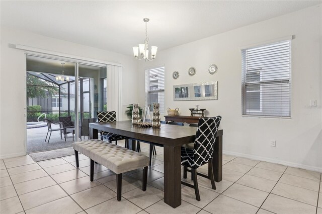 7033 Oakwood St, Davenport, FL 33837 - dining room with a chandelier, plenty of natural light, light tile patterned floors, and baseboards