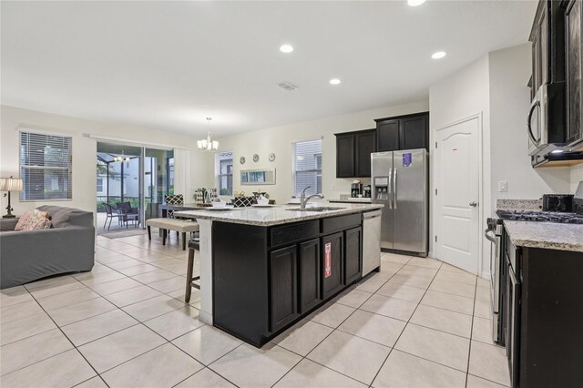7033 Oakwood St, Davenport, FL 33837 - kitchen with a sink, stainless steel appliances, dark cabinets, open floor plan, and recessed lighting