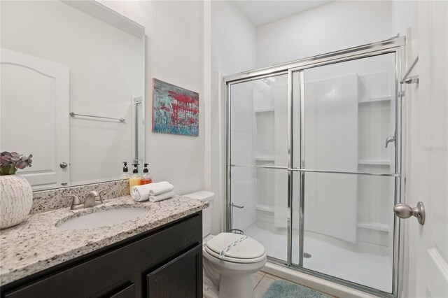 7033 Oakwood St, Davenport, FL 33837 - bathroom featuring a shower stall, vanity, toilet, and tile patterned floors