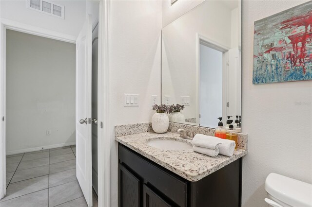 7033 Oakwood St, Davenport, FL 33837 - half bathroom featuring vanity, toilet, and tile patterned flooring