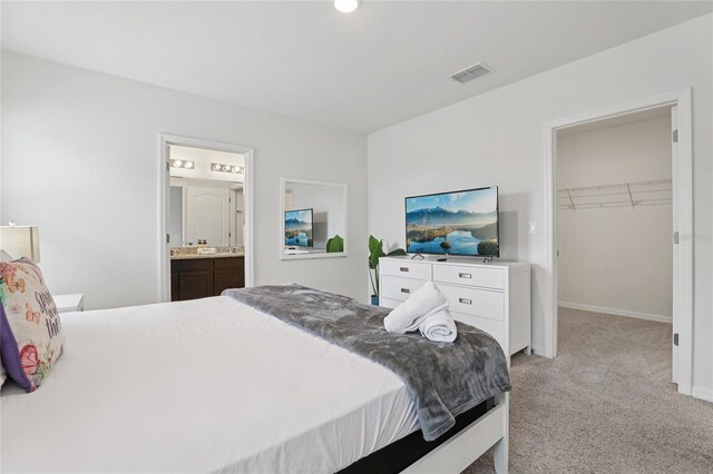 7033 Oakwood St, Davenport, FL 33837 - carpeted bedroom featuring a walk in closet, connected bathroom, a closet, and baseboards