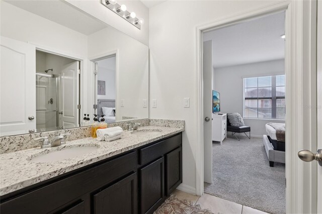 7033 Oakwood St, Davenport, FL 33837 - ensuite bathroom featuring double vanity, a stall shower, tile patterned floors, and baseboards